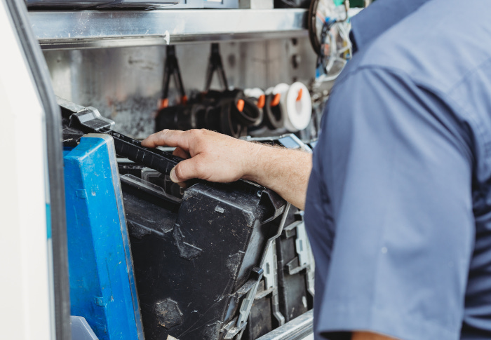 assure plumber getting tools from a car