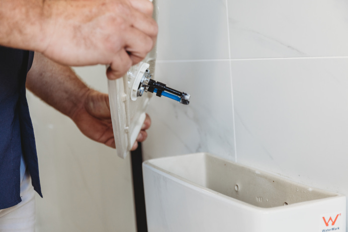 assure fix plumber repairing toilet