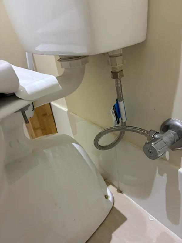 Close-up of toilet cistern plumbing connection
